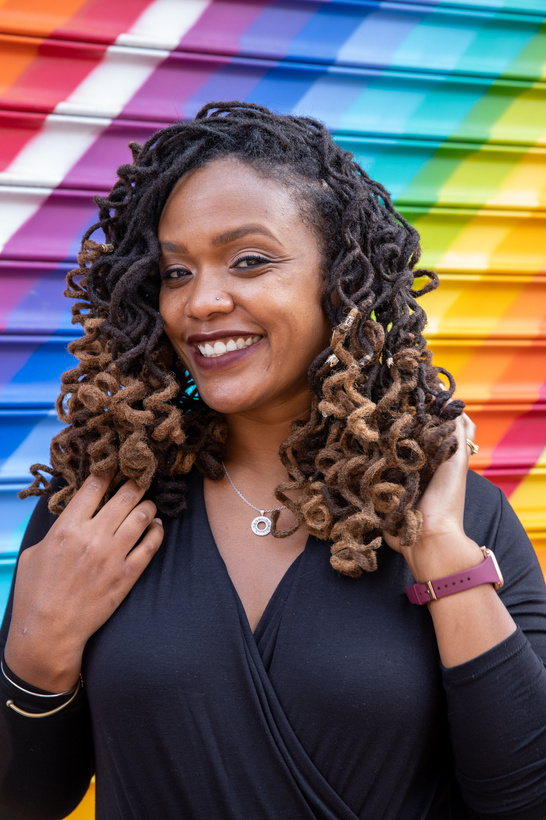 Portrait of Smiling Woman in Dreadlocks against Colorful Wall
